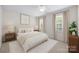 Staged bedroom with neutral colors, ceiling fan, and bright natural light at 10600 Four Mile Creek Rd, Charlotte, NC 28277