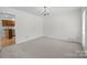 Neutral empty room with white trim and carpet floor, featuring an entry to the kitchen at 10600 Four Mile Creek Rd, Charlotte, NC 28277