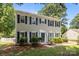 Traditional two-story home featuring light siding and contrasting blue shutters and door, framed by mature trees at 10600 Four Mile Creek Rd, Charlotte, NC 28277