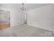 Bright, carpeted living room with neutral walls and a classic chandelier, perfect for comfortable living at 10600 Four Mile Creek Rd, Charlotte, NC 28277