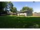Backyard view featuring a well-kept lawn and a stone patio with stylish landscaping at 1114 Urban Pl, Charlotte, NC 28209