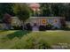 Charming single story home featuring a brick facade, well-manicured lawn, mature trees and a vibrant landscape at 1114 Urban Pl, Charlotte, NC 28209