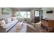 Comfortable living room with large window, stylish furniture, hardwood flooring, and neutral color palette at 1114 Urban Pl, Charlotte, NC 28209