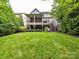 Expansive backyard with a covered deck, manicured lawn, and mature landscaping creating a private oasis at 1118 Yale Pl, Charlotte, NC 28209