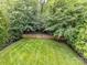 Manicured backyard with a wooden fence and mature trees offering privacy and beauty at 1118 Yale Pl, Charlotte, NC 28209