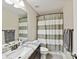 Well-lit bathroom featuring a granite countertop, framed mirror, and a shower with a striped curtain at 1118 Yale Pl, Charlotte, NC 28209