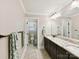 Well-lit bathroom offers double granite vanity, framed mirror, and tile flooring at 1118 Yale Pl, Charlotte, NC 28209