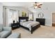 Serene main bedroom featuring neutral tones, a ceiling fan, and natural light from shuttered windows at 1118 Yale Pl, Charlotte, NC 28209