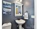 Stylish powder room features a pedestal sink, decorative mirror, and modern fixtures at 1118 Yale Pl, Charlotte, NC 28209