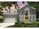 Charming two-story home with a well-maintained lawn, attached garage, and beautiful architectural details at 12411 Herdon Ct, Charlotte, NC 28277