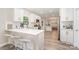 Modern kitchen with white cabinets, quartz countertops, stainless steel appliances, and breakfast bar seating at 12411 Herdon Ct, Charlotte, NC 28277