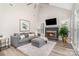 Comfortable living room with vaulted ceiling, fireplace, and stylish seating, flooded with natural light at 12411 Herdon Ct, Charlotte, NC 28277