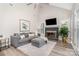 Comfortable living room with vaulted ceiling, fireplace, and stylish seating, flooded with natural light at 12411 Herdon Ct, Charlotte, NC 28277
