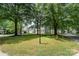 Street view of home with mature trees, grassy median and street signage at 12411 Herdon Ct, Charlotte, NC 28277