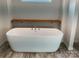 A standalone white bathtub is featured in the bathroom with wood-look flooring at 126 Zircon Dr, Statesville, NC 28625