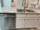 Close-up of a kitchen island with stainless steel dishwasher, sink, and white cabinets at 126 Zircon Dr, Statesville, NC 28625