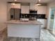 Stylish kitchen with white cabinets, stainless steel appliances, island, and dark backsplash at 126 Zircon Dr, Statesville, NC 28625