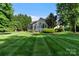 Beautifully landscaped backyard with lush lawn, screened porch, and patio perfect for outdoor living at 132 Ragsdale Trl, Mooresville, NC 28117