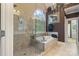 Bright bathroom with a tiled shower, soaking tub, and windows allowing natural light at 132 Ragsdale Trl, Mooresville, NC 28117