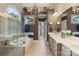 Elegant bathroom featuring a soaking tub, walk-in shower, chandelier, and dual sinks at 132 Ragsdale Trl, Mooresville, NC 28117