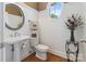 Charming powder room with a pedestal sink, round window, and beadboard walls at 132 Ragsdale Trl, Mooresville, NC 28117