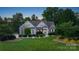 Charming home with a well-manicured lawn, stone accents, and mature trees at twilight at 132 Ragsdale Trl, Mooresville, NC 28117