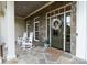Inviting front porch with rocking chairs, stone accents, and decorative wreath at 132 Ragsdale Trl, Mooresville, NC 28117