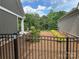 View of the landscaped backyard featuring a black metal fence and green grass at 1330 Millview Ln, Matthews, NC 28104