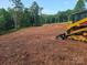 Cleared lot showcasing the land with a work vehicle, perfect for building your dream home at 138 Broken Arrow Rd, Statesville, NC 28677