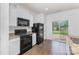 Eat-in kitchen featuring sleek white cabinets, stainless steel appliances, and sliding doors to backyard at 1404 Waylon Ave, Gastonia, NC 28054