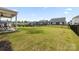 Spacious backyard featuring a large grassy area, black metal fence, and covered patio at 14116 Glaswick Dr, Charlotte, NC 28278