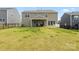 Large backyard featuring a covered patio, lush lawn, and black metal fencing at 14116 Glaswick Dr, Charlotte, NC 28278