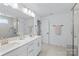 Bathroom with double sinks, modern fixtures, quartz counters, and a glass-enclosed shower at 14116 Glaswick Dr, Charlotte, NC 28278