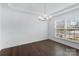Empty dining room with dark hardwood floors, a modern chandelier, and large windows at 14116 Glaswick Dr, Charlotte, NC 28278
