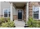 Inviting front entrance with stone accents, a black door, and manicured landscaping at 14116 Glaswick Dr, Charlotte, NC 28278