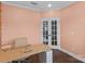 Home office featuring light salmon paint, hardwood floors, and white French doors at 14116 Glaswick Dr, Charlotte, NC 28278