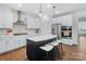 Modern kitchen features an island with seating, a stainless steel fridge, and modern appliances at 14116 Glaswick Dr, Charlotte, NC 28278