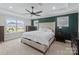Spacious main bedroom with dark green accent wall, trey ceiling, ceiling fan, and a large window at 14116 Glaswick Dr, Charlotte, NC 28278