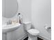 A clean powder room with a pedestal sink, round mirror, and modern toilet at 14116 Glaswick Dr, Charlotte, NC 28278