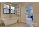 Bright bathroom featuring a luxurious soaking tub, built-in shelving, and an open doorway at 1427 Main St, Charlotte, NC 28204