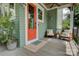 Inviting porch area with seating, providing a relaxing outdoor space with green siding and orange door at 1427 Main St, Charlotte, NC 28204