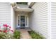 Close up of front entrance with glass storm door and colorful landscaping at 1445 Deer Forest Dr, Indian Land, SC 29707