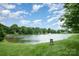 A view of the pond within Legacy Park that is surrounded by trees and lush green grass at 1445 Deer Forest Dr, Indian Land, SC 29707
