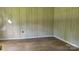Bedroom interior exhibiting wood paneling, wood laminate flooring, and signs of wear at 1672 Riverview Rd, Lincolnton, NC 28092