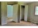 Bedroom with wood-paneled walls, closet with open doors, and worn hardwood floors at 1672 Riverview Rd, Lincolnton, NC 28092