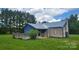 A quaint single story home with a metal roof and a wooden deck on a grassy lot at 1672 Riverview Rd, Lincolnton, NC 28092