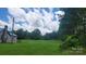 The large grassy field features a charming home at the edge of a wooded area at 1672 Riverview Rd, Lincolnton, NC 28092