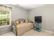 Charming bedroom features natural light, a daybed, and a modern media center on a teal colored shelving unit at 171 Highland Woods Ct, Denver, NC 28037