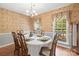 Formal dining room with patterned wallpaper, wood floors, and chandelier lighting at 171 Highland Woods Ct, Denver, NC 28037