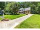 Two-story brick home with a welcoming front porch, lush green lawn, and a long driveway at 171 Highland Woods Ct, Denver, NC 28037